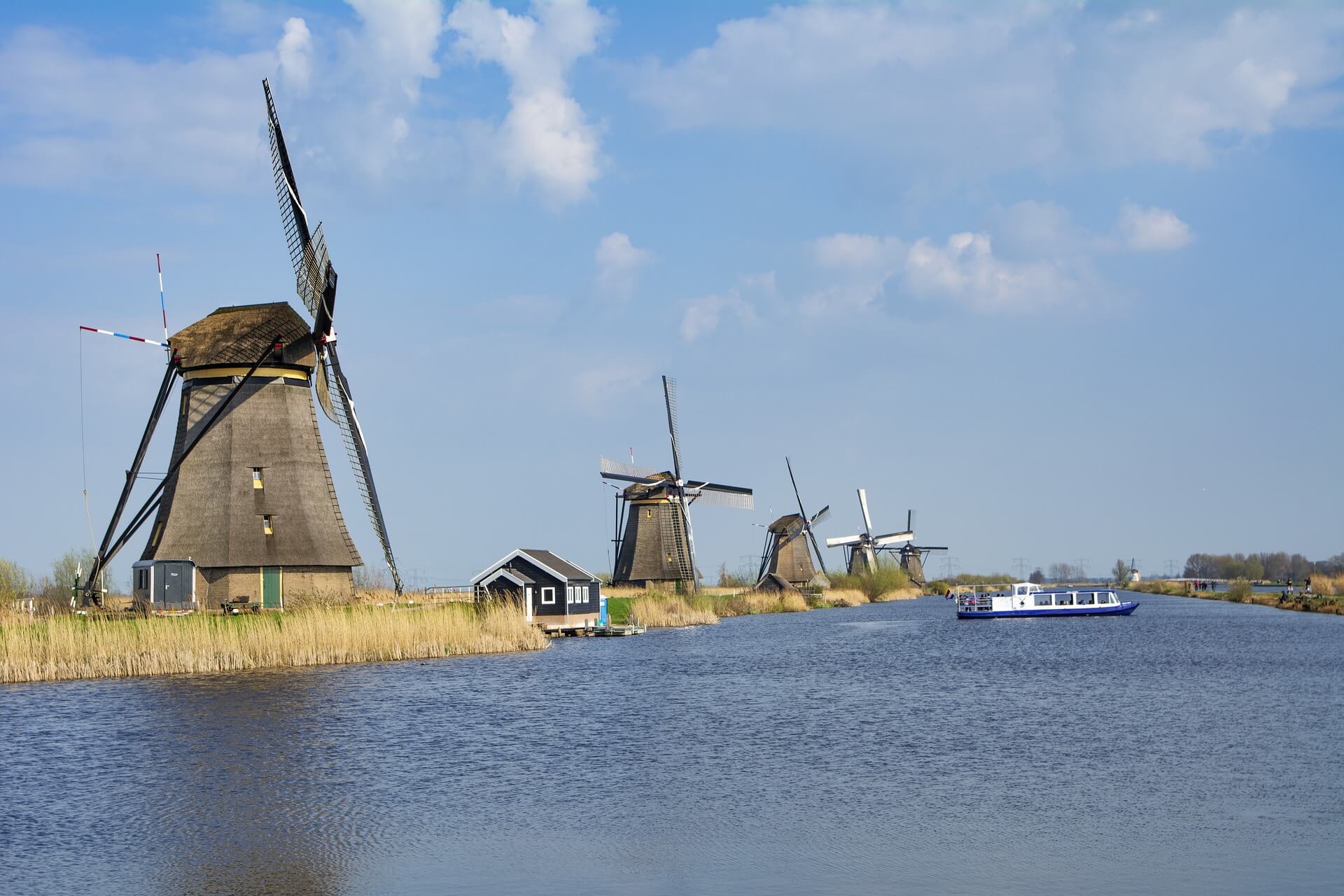 Molens in Zuid Holland aan water met boot (Kinderdijk)